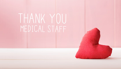 Thank You Medical Staff message with a red heart cushion over a pink wooden wall