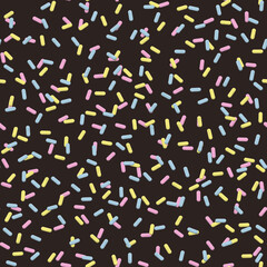 big pink blue and yellow sprinkles seamless pattern on a dark chocolate brown background 