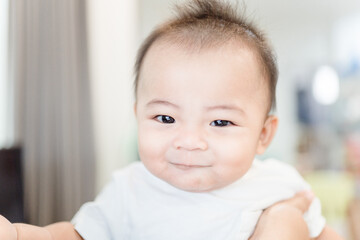 smiling cute baby boy stay at home.Asian child infant 6 month laughing looking at camera wearing white t-shirt.Infant, People, Healthcare, Pediatric, Healthy lifestyle.Active kid with smile good mood.