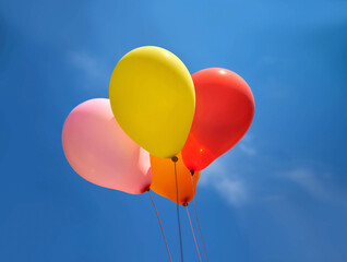 Colorful balloons on a blue sky with light clouds