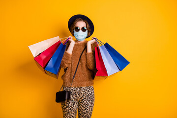Portrait of her she fashionable lady wearing gauze mask visiting mall center after quarantine opening hold many packs low prices isolated bright vivid shine vibrant yellow color background