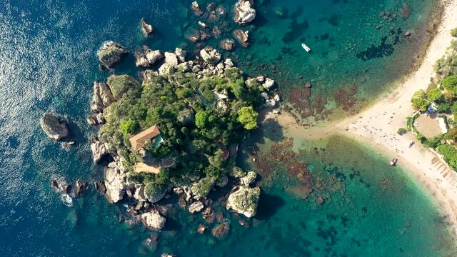 Aerial view of Isola Bella in Taormina, Sicily, Italy. Isola Bella is small island near Taormina, Sicily, Italy. Narrow path connects island to mainland Taormina beach in azure waters of Ionian Sea.