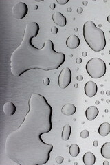 Abstract art texture background of water drops on an exterior brushed stainless steel surface following rain precipitation