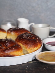 Homemade cake.Buns sprinkled with sesame and sugar syrup with ingredients on a dark wooden table with a gray background.