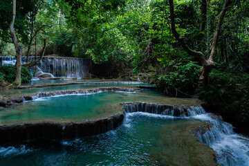 Kuangsi Waterfall, lower level. The water cascades over the embankments creating beautiful pools that are used for swimming by locals and tourists in Luang Prabang, Laos.
