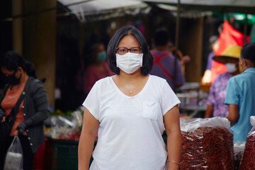 woman in masks for protection against viruses and flu on busy market streets