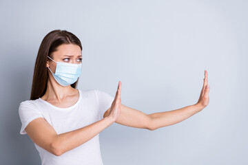 Photo of serious lady keep social distance avoid afraid of people contact raise arms side empty space stay away from me concept wear protect face mask isolated grey color background