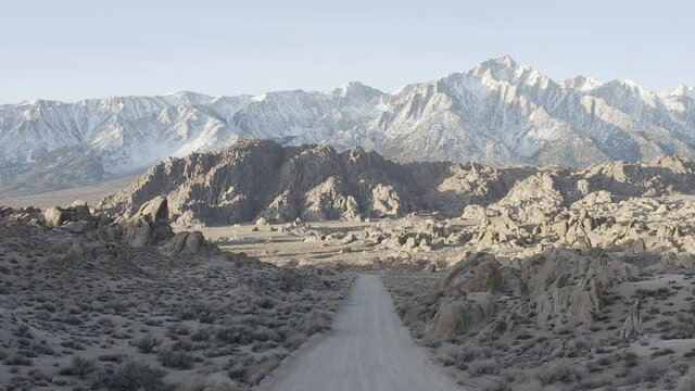 dolly shot over a road in Alabama hills, california, during the sunrise. Mountains in the background.