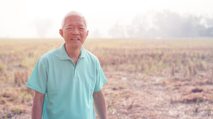 Asian elderly stand with their farm after harvested at the end of season