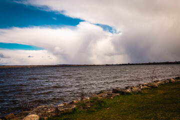 Storm clouds approach over a river
