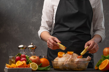 Culinary recipes, cooking chicken, meat with vegetables, fruits. Against the background of a gray wall. Menu and restaurant business, home comfort