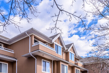 A perfect neighborhood. Houses in suburb at Summer in the north America. Top of a luxury house with nice window over blue sky.