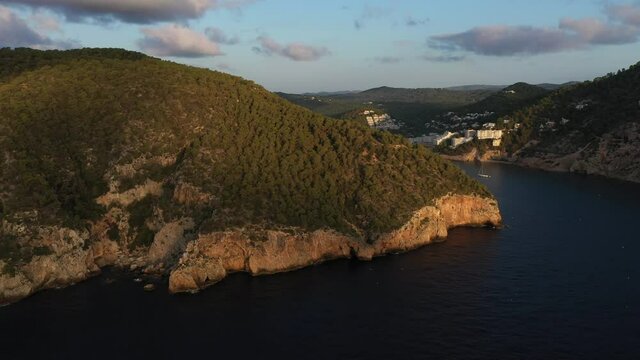Aerial view of Cala Llonga beach, located in southern Ibiza, Spain. Beautiful aerial view of the bay at sunset