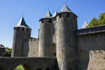Fototapeta na wymiar France, Carcassonne— AUGUST 28, 2014. Powerful fortifications and bastions of Carcassonne Castle. Beautiful conical blue roofs of towers. Bridge and entrance to the central fortress