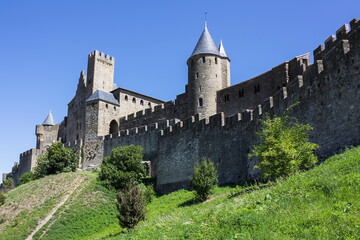 Fototapeta na wymiar France, Carcassonne- AUGUST 28, 2014. Powerful fortifications and bastions of Carcassonne Castle. Beautiful conical blue roofs of towers.