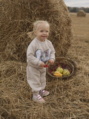 Little girl next to a bale of wheat