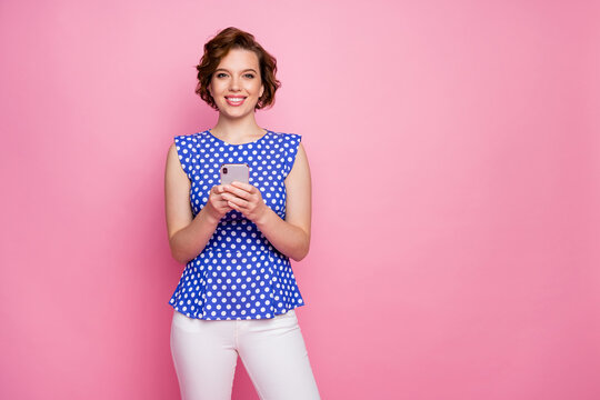 Portrait of her she nice attractive lovely pretty cheerful cheery brown-haired girl holding in hands cell device browsing smm feedback isolated over pink pastel color background