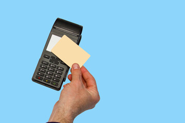 The hand holds a credit card on the payment terminal. Isolated on blue background
