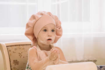 Little girl cooks at home in the kitchen