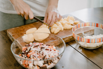 in the foreground a housewife in a white t shirt is preparing to eat the background is the interior of the kitchen