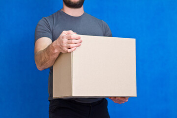 The box is in the hands of the man of the supplier who delivers the parcel