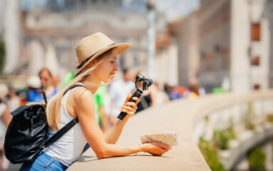 Rome Europe Italia travel summer tourism holiday vacation background -young smiling girl with mobile phone camera and map in hand standing on the hill looking on the cathedral Vatican