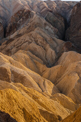 Golden Canyon in Death Valley National Park in the USA. Textured colorful rocky golden peaks in Golden Canyon California 