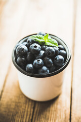 Freshly harvested blueberries in metal cup. Selective focus. Shallow depth of field.
