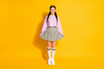 Full length body size view of her she nice attractive lovely pretty fashionable modest cheerful cheery girl posing isolated over bright vivid shine vibrant yellow color background
