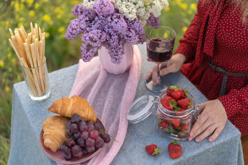 French style romantic summer picnic. Flat glasses of rose wine, fresh strawberries, croissants, brie cheese..