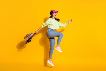 Fototapeta na wymiar Full size profile side photo of cheerful funny carefree childish playful girl enjoy summer tour jump wear headwear bag backpack gumshoes isolated over bright shine color background