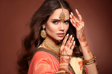 Mehendi. Portrait of beautiful indian girl in sari. Young hindu woman model with kundan golden...