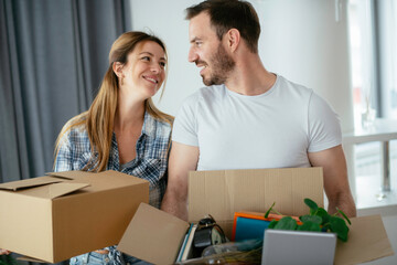 Boyfriend and girlfriend moving in a apartment. Boyfriend and girlfriend are unpacking their belongins.	