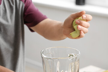 Man making healthy smoothie at home, closeup