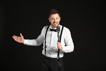 Handsome man singing against dark background