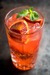 Red cocktail with blood oranges and mint on the rustic background. Selective focus. Shallow depth of field.