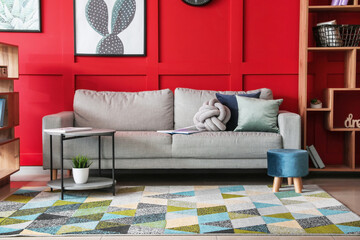 Stylish interior of living room with carpet and sofa