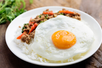 Thai food, stir-fried holy basil with minced pork and fried egg (Pad Kaprao Moo Kai Dao) on plate 