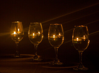 glasses at night lit by candles with black background