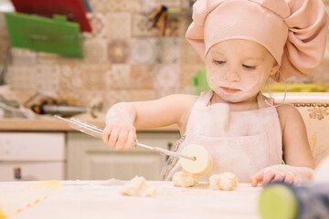 Little girl cooks at home in the kitchen
