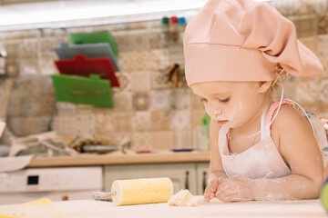 Little girl cooks at home in the kitchen