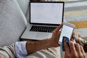 Close-up of man cleaning his smart phone.