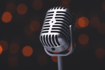 Fototapeta na wymiar Retro microphone on dark background with blurred lights