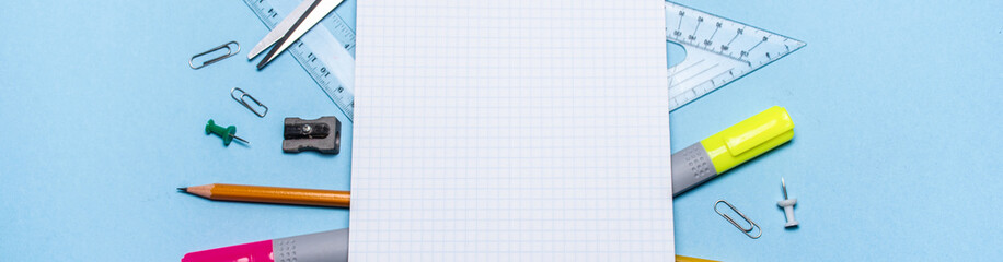 School supplies at the notebook on a blue background. The view from the top. Mock up school banner. Back to school!