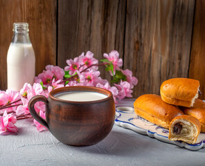 Breakfast rolls with chocolate filling and milk on a wooden rustic background