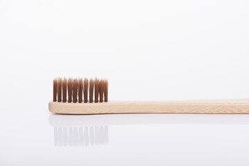 Zero waste concept. Close-up side profile macro view photo of eco-friendly brown toothbrush isolated on white background