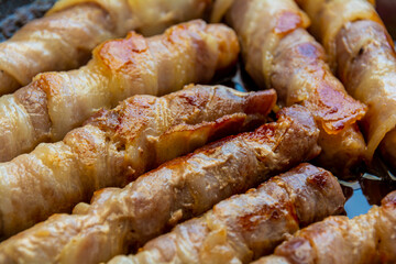 Fried sausages in bacon. bacon roll closeup. Abstract background with bacon.