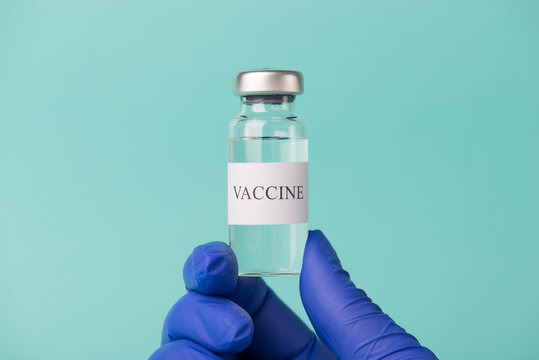 Immunization lab laboratory concept. Close-up cropped photo of doctor holding a vaccine vial isolated on blue turquoise background