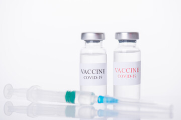 Immunization and COVID-19 treatment concept. Close-up photo of two COVID-19 vaccine vials and shot isolated on white background