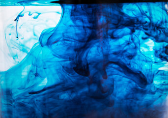 Blue color spilled in water. Movement of paint in a liquid